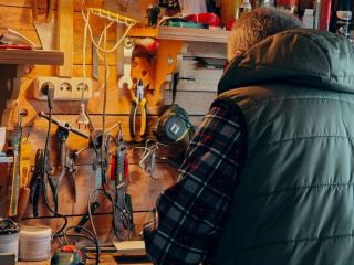 Batterie d'outil sans fil posée près de son chargeur sur un établi
